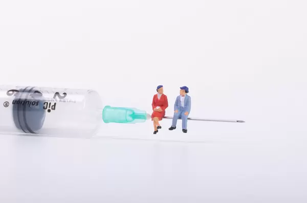 Older couple sitting on a syringe
