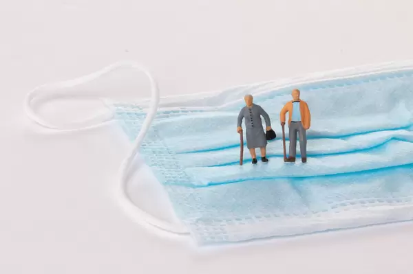 Older couple standing on medical face mask