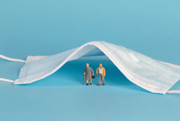 Older couple standing under medical face mask