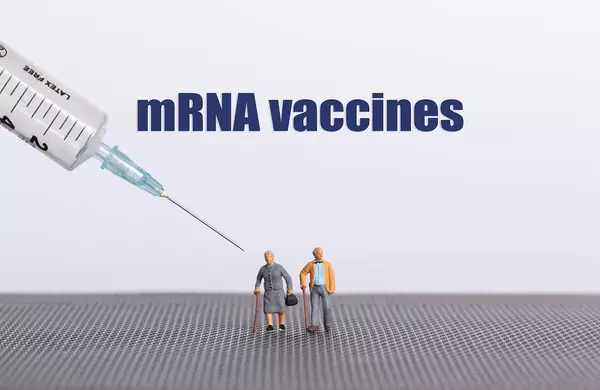 Older couple with syringe and mRNA vaccines text