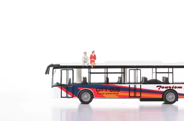 Older man and women sitting on a top of city bus