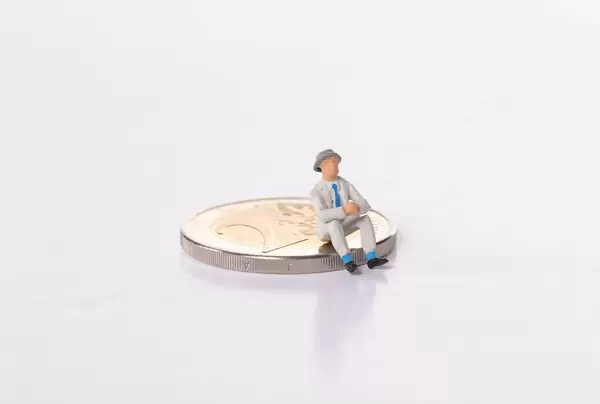 Older man sitting 2 Euro coin