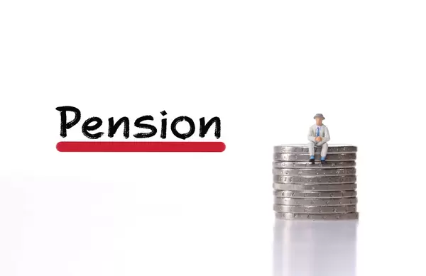 Older man sitting on stack of coins with Pension text
