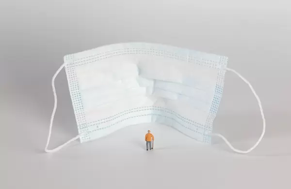 Older man standing in front of medical face mask