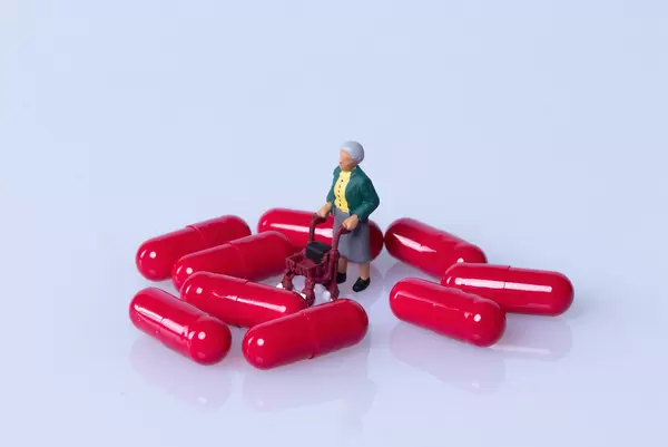 Older woman with red pills