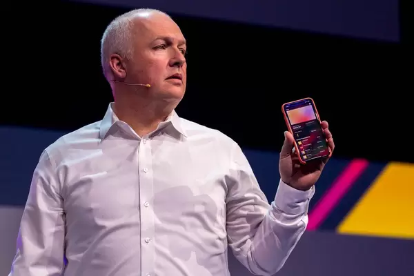 Oliver Ratzesberger von Teradata hält ein iPhone in der Hand, das eine Liste von Apple Card Transaktionen auf dem Display anzeigt