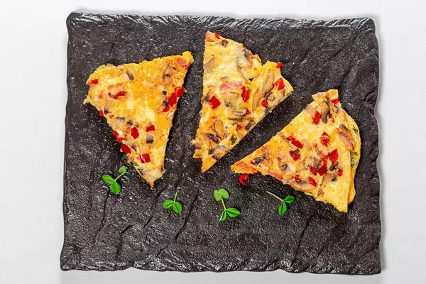 Omelet slices with vegetables and mushrooms. Top view (Flip 2019)