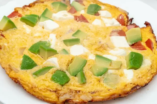 Omelet with Avocado Cheese and Tomatoes on the plate (Flip 2019)