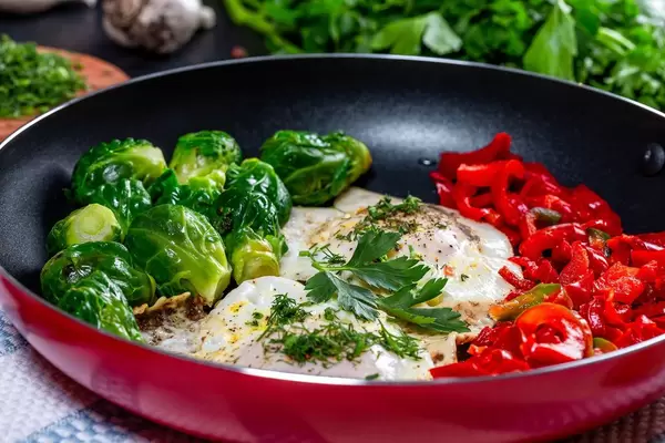 Omelet with Brussels sprouts and bell pepper in a frying pan (Flip 2019)