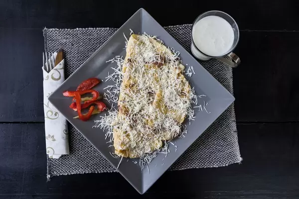 Omelett mit geriebenem Käse und Glas Milch. Draufsicht