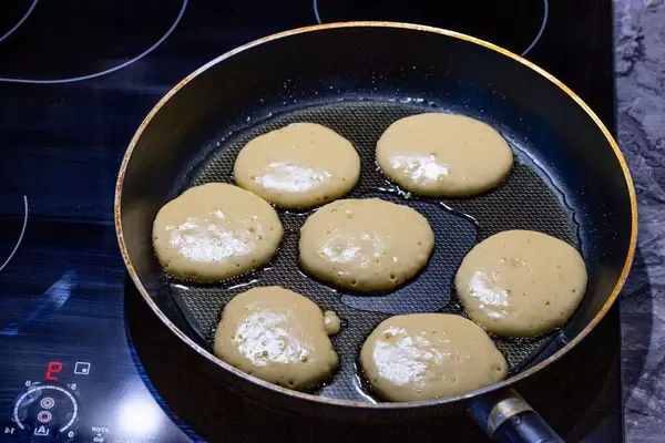 On the electronic cooking surface fried pancakes in a frying pan (Flip 2019)