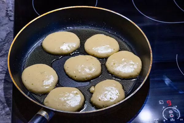 On the electronic cooking surface fried pancakes in a frying pan