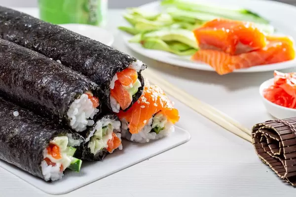 On white table, the ingredients for sushi and ready rolls on the kitchen Board (Flip 2019)