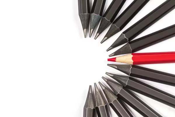 One red pencil among many black ones