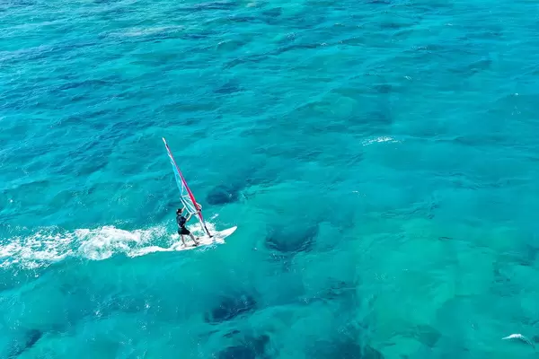 One windsurfer in the blue sea waters of Mikri Vigla, windsurf spot on the island of Naxos, Greece