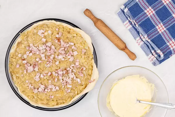 Onion Pie with sliced Bacon on the table ready for baking