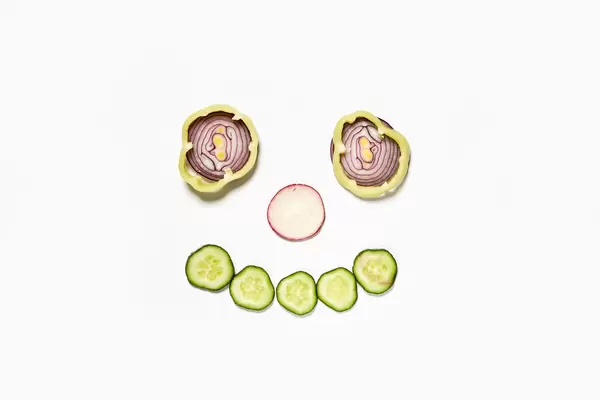 Onion rings and cucumber cuts making a smiling face
