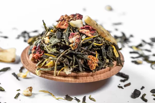 Oolong green tea with dried strawberries on a white