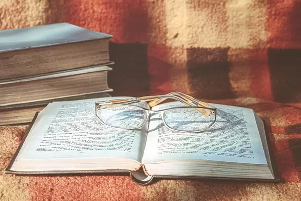 Open book and glasses on the blanket. The concept of reading (Flip 2019)