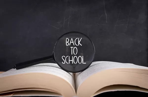 Open book with magnifier and Back to School text