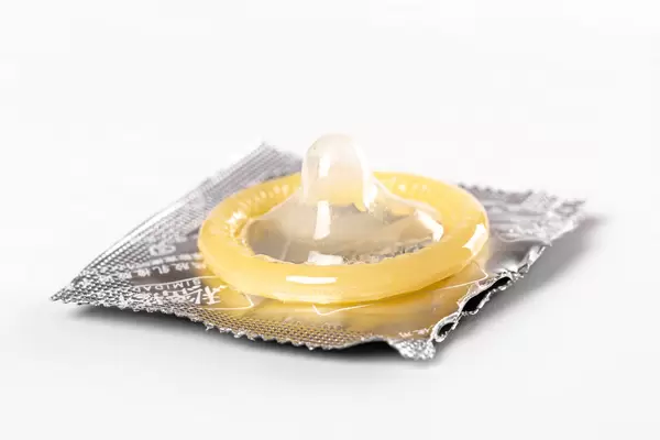 Open condom on a white background