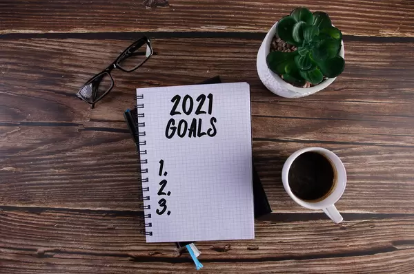 Open notebook with 2021 Goals list on wooden table