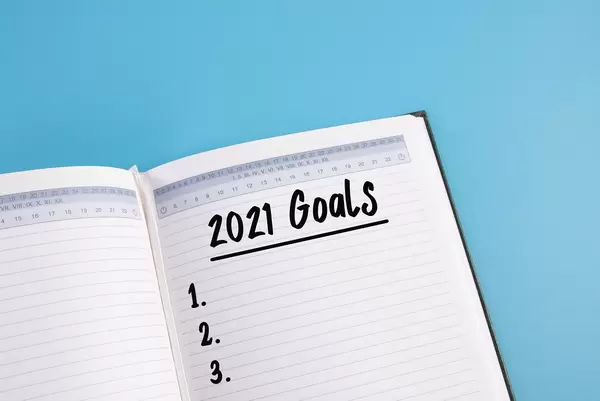 Open notebook with 2021 Goals text on blue background