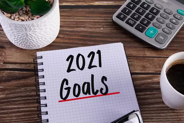 Open notebook with 2021 Goals text on wooden table