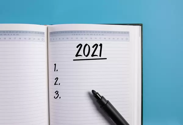 Open notebook with 2021 list on blue background