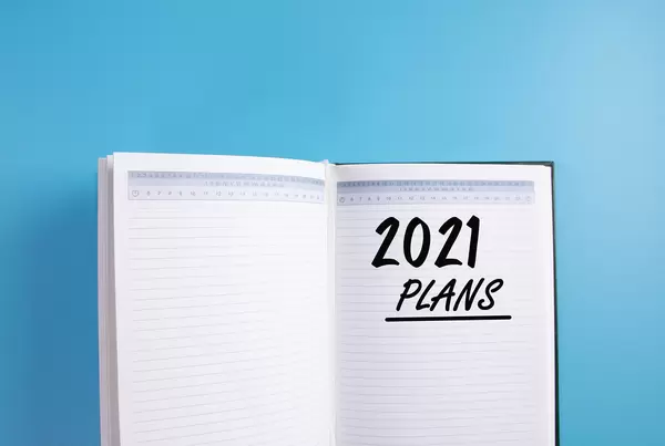 Open notebook with 2021 Plans text on blue background