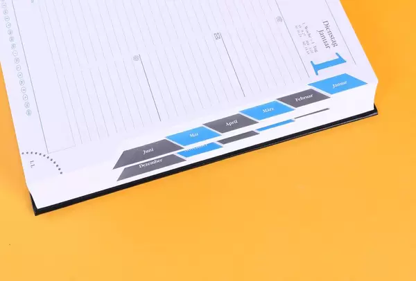 Open notebook with months list on orange background