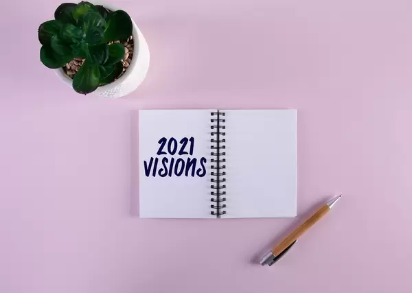 Open notebook with pen and 2021 Visions text