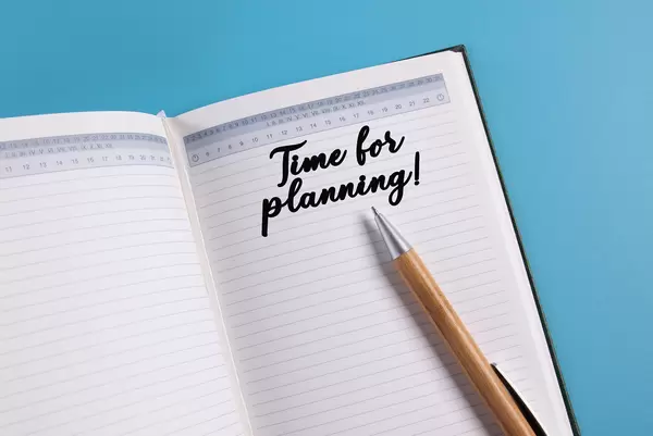 Open notebook with Time for planning text on blue background