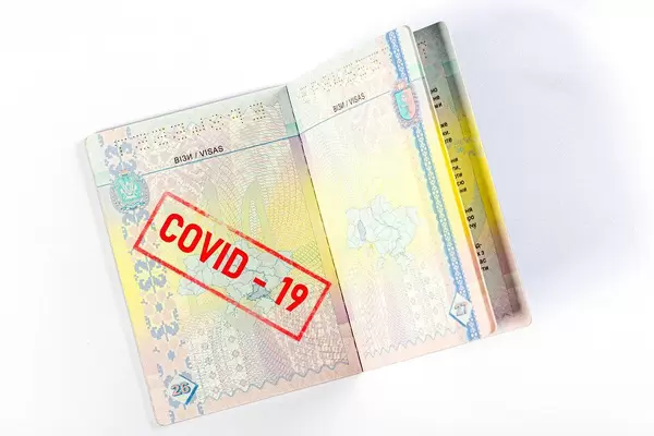 Open passport with covid-19 red stamp