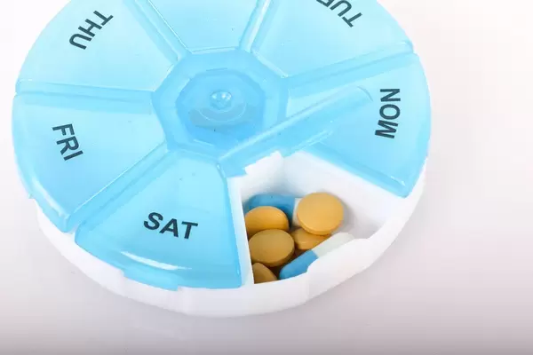 Open pill reminder box on white background