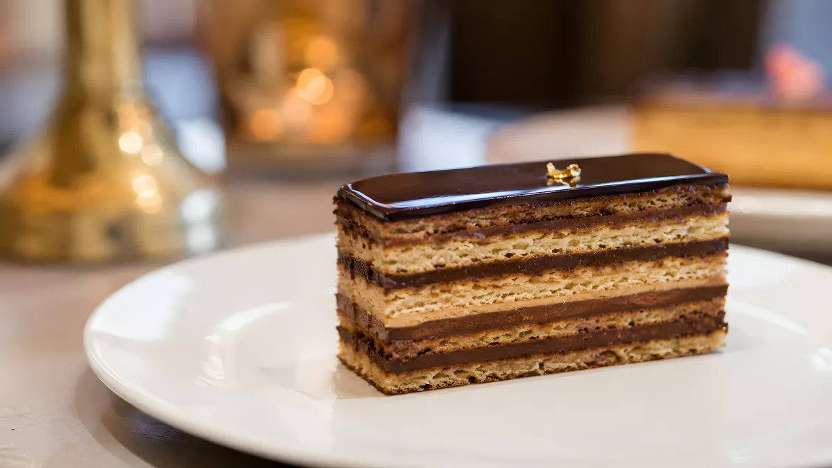 Opéra-Torte mit Schokoladenglasur auf weißem Teller