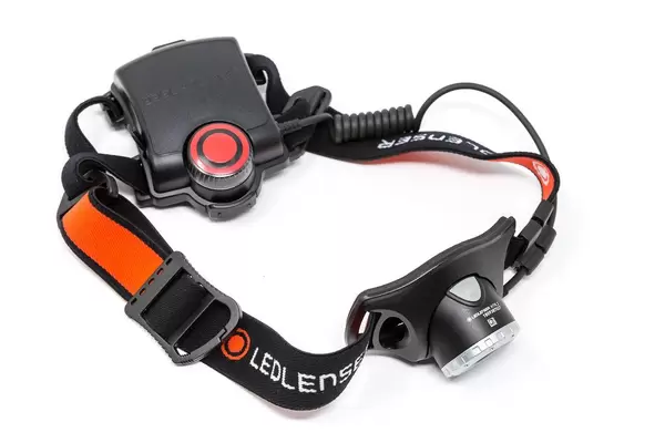Orange-black headlamp Ledlenser H7R.2 in front of white background