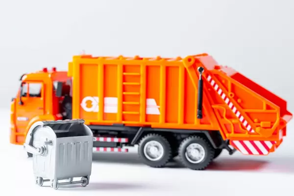 Orange garbage truck toy on a white background