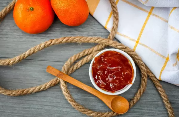 Orange Jam With Wooden Spoon Top View