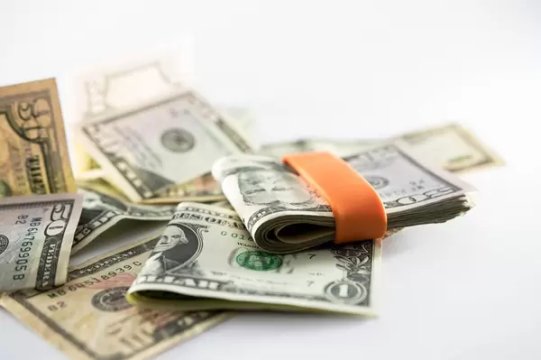 Orange money band holding dollar bills