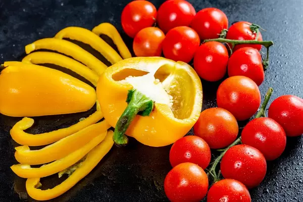 Orange pepper with tomato branches on black background  Flip 2019