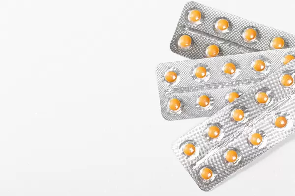 Orange pills in blisters on a white background with free space (Flip 2019)