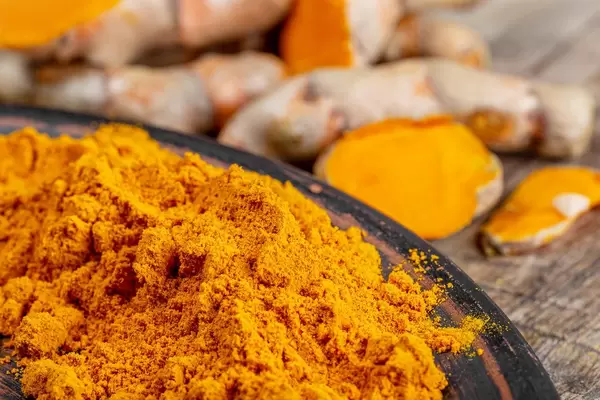 Orange turmeric powder with fresh turmeric