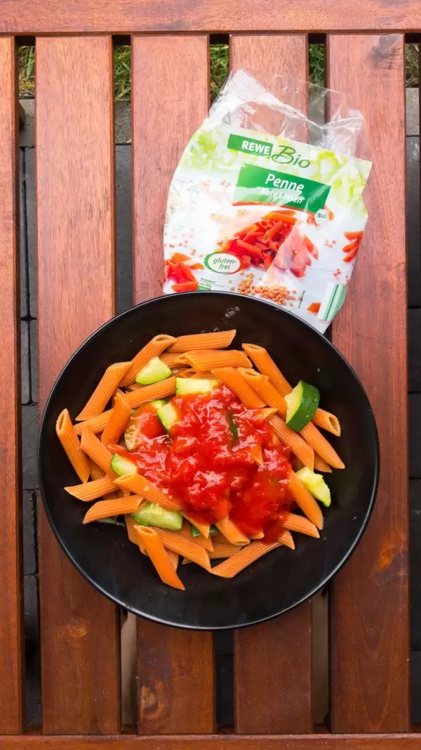 Orangefarbene Bio-Penne aus roten Linsen, Zucchini und Tomatensoße