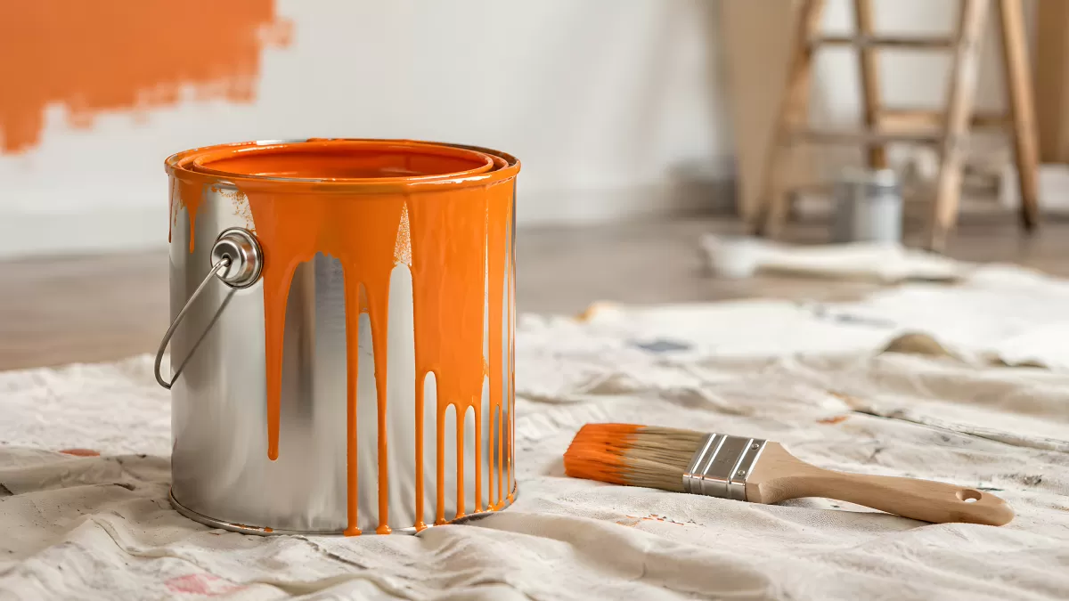 Orangefarbene Farbe läuft an Metalleimer herunter