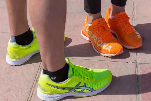 Orangefarbene und hellgrüne ASICS Laufschuhe