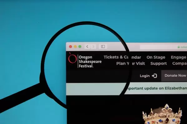 Oregon Shakespeare Festival logo on a computer screen with a magnifying glass