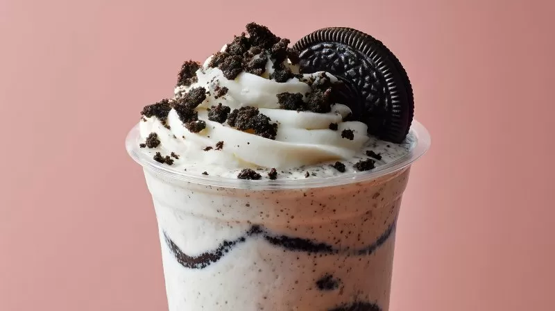 Oreo-Milchshake mit Sahne und Keks auf rosa Hintergrund