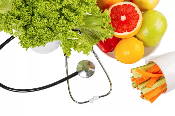 Organic fresh fruits and vegetables with stethoscope on white background