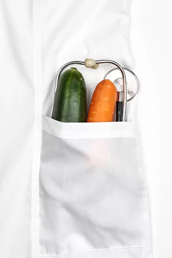 Organic ripe vegetables in pocket of white doctor's coat